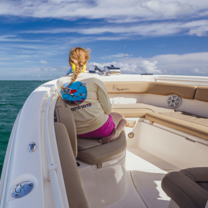 A woman sitting in the back of a Grateful Diver Skeleton Diver Short Sleeve UV Shirt.