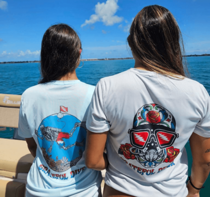 Two women wearing Grateful Diver Sugar Skull Short Sleeve UV shirts on a boat.