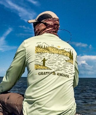 Man fishing in ocean wearing Grateful Angler UV fishing shirt with Key West scenery.