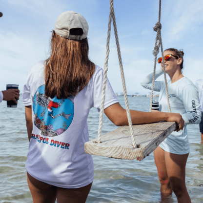 A group of people standing on a Grateful Diver Skeleton Diver Short Sleeve UV Shirt in the water.