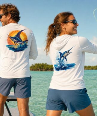 A man poling a flats skiff from the platform while a woman fly casts from the bow near Key West, wearing the Blue Marlin sun hoodie and Sailfish long sleeve